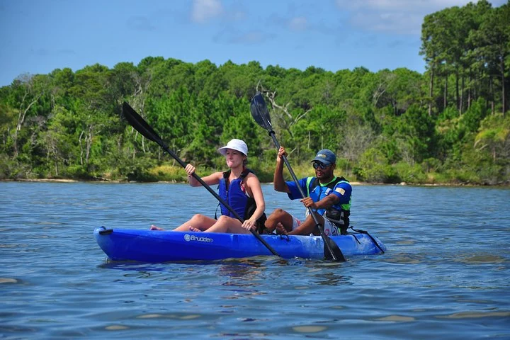 Two people kayaking on the calm water of Rio Vermelho