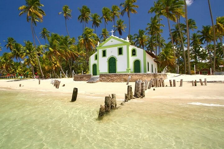 Chapelle São Benedito parmi les palmiers et l'eau claire à Praia dos Carneiros