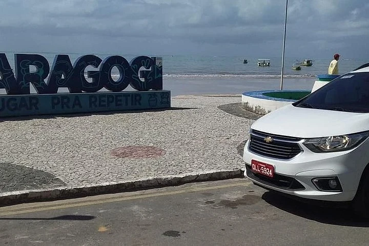 Panneau de Maragogi près du front de mer et des bateaux
