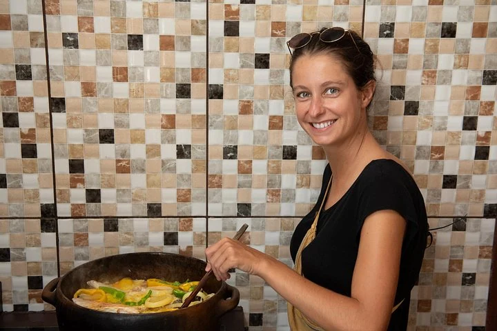 Participante préparant une moqueca dans un cours de cuisine à Salvador