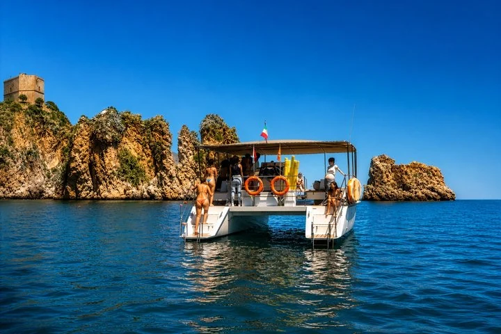 Catamaran devant les rochers et la tour de Scopello