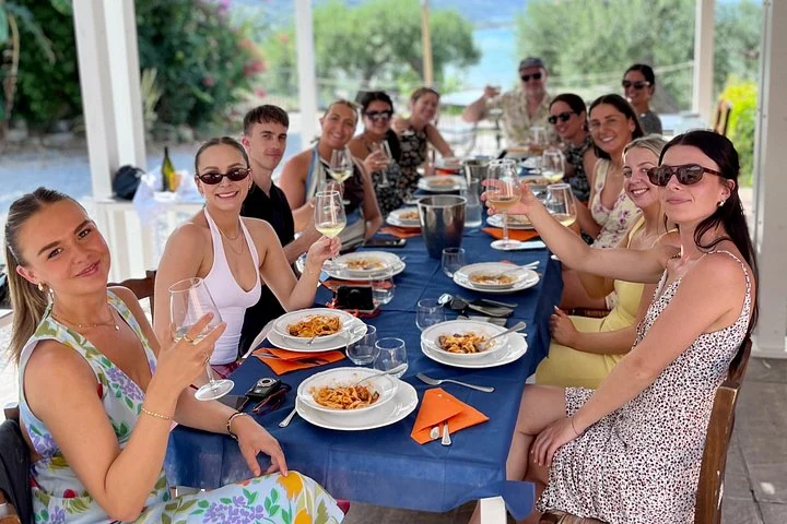 Groupe partageant des plats de pâtes après un atelier de cuisine près de Cefalù