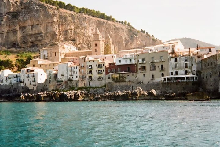 Cathedral towers and coastal houses in Cefalù beneath the Rocca