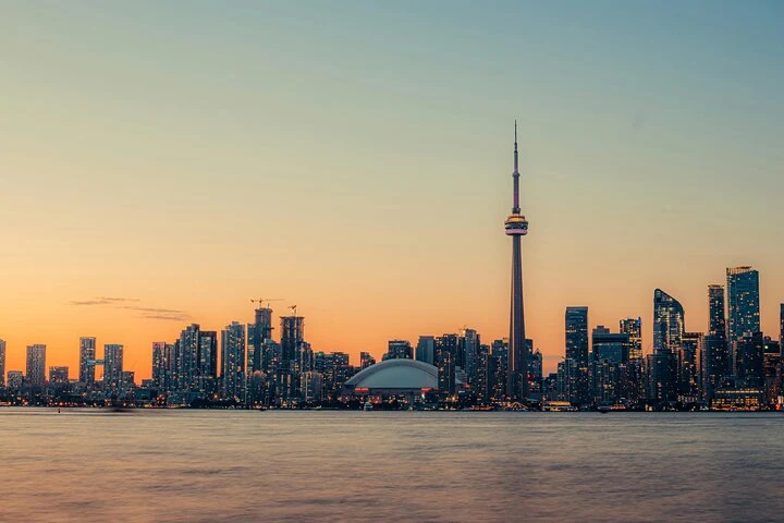 Toronto skyline and CN Tower beside the water at sunset