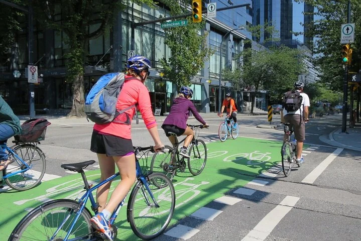 Eine Radgruppe fährt auf einem grün markierten Radweg in der Innenstadt von Vancouver.