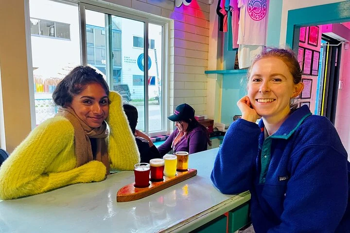 Zwei Besucherinnen sitzen neben einer Bierverkostung in einem Lokal in Vancouver.