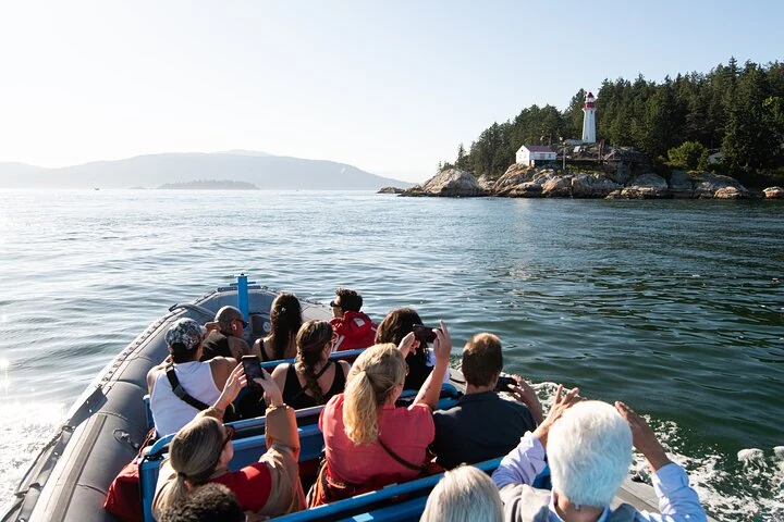 Gäste nähern sich in einem Boot dem Leuchtturm von Point Atkinson in West Vancouver, außerhalb der Stadt Vancouver.