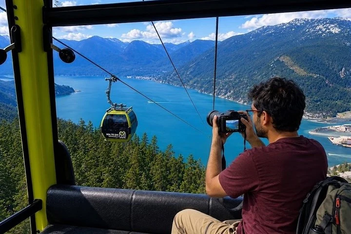 Eine Person fotografiert Howe Sound aus einer Kabine der Sea to Sky Gondola in Squamish, außerhalb von Vancouver.