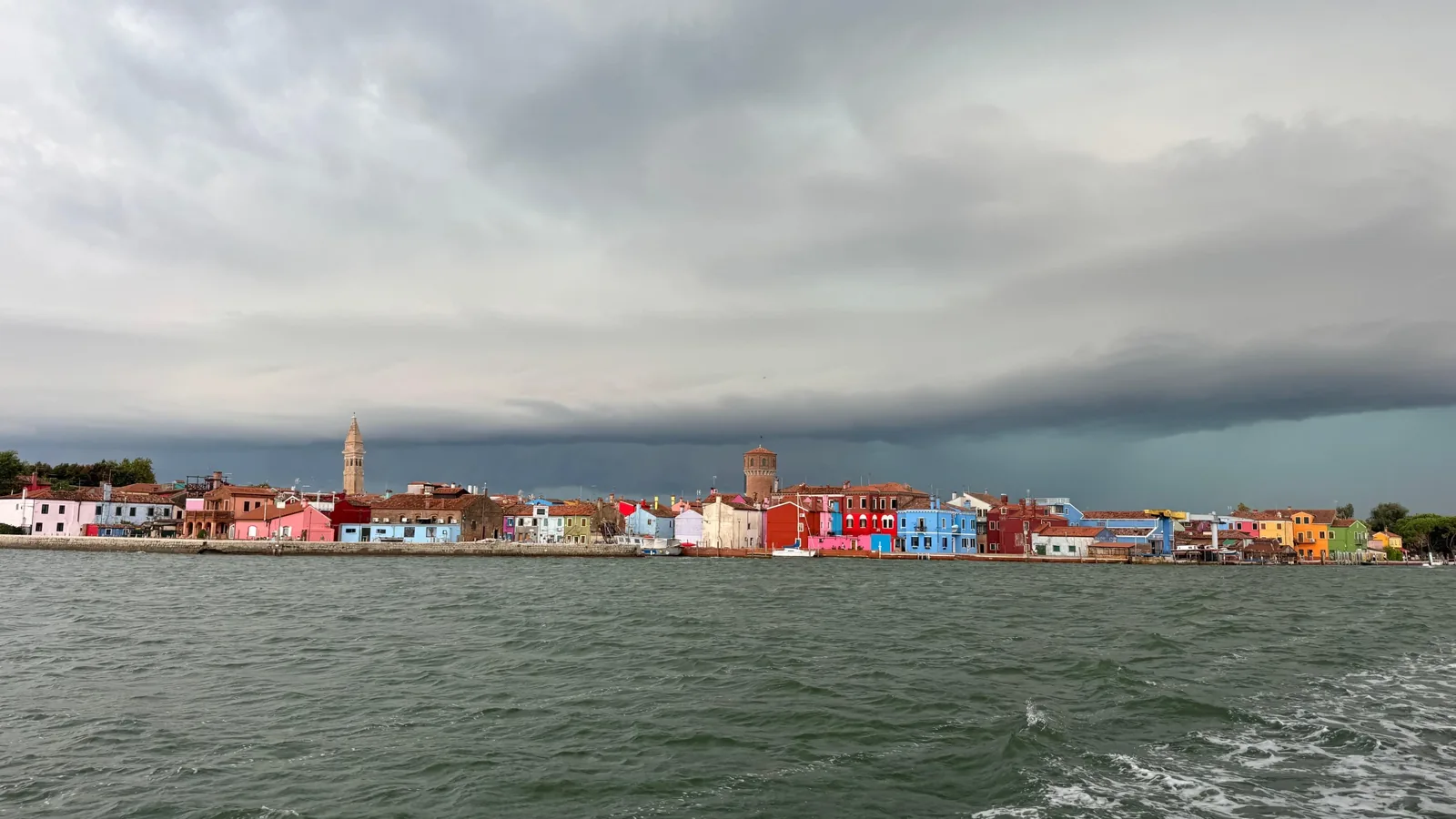 Bunte Häuser am Wasser, von einem Boot in der Lagune Venedigs aus gesehen