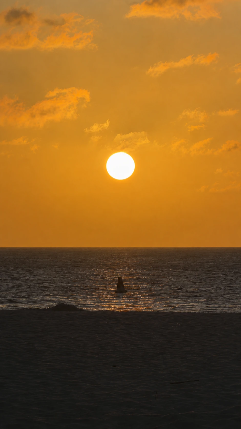 Soleil orange se couchant sur la mer à Eagle Beach