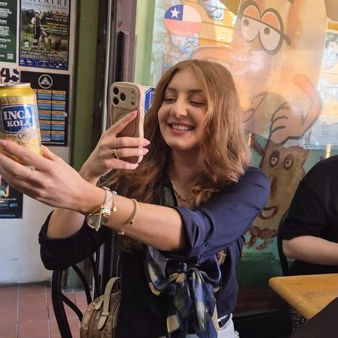 A visitor takes a selfie while holding a can.