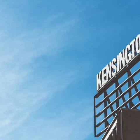 Der Schriftzug Kensington an einem Gebäude unter blauem Himmel.