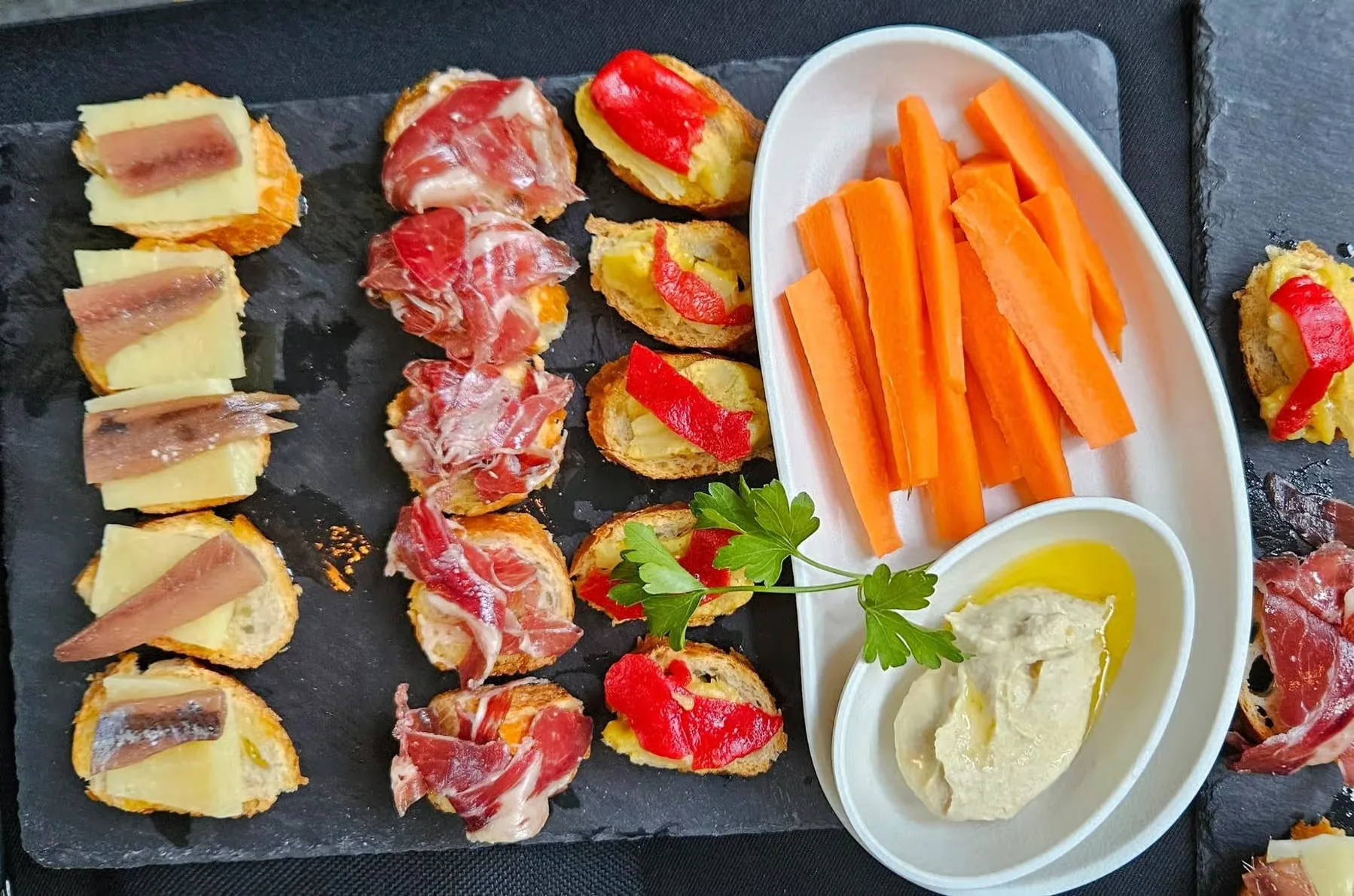 Sail along Barcelona at sunset with tapas and drinks included